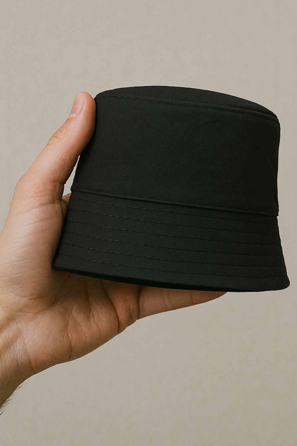 Nón bucket màu đen được gấp gọn trên tay