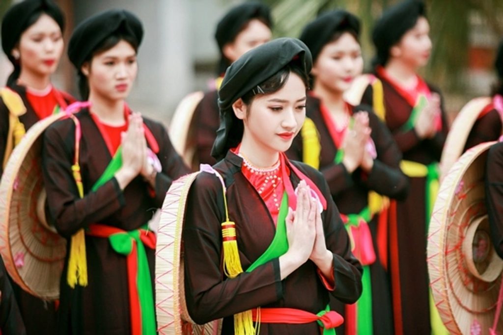 Thiếu nữ mặc áo tứ thân đội nón quai thao trong hội làng
