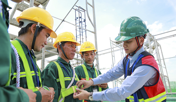 Công nhân đội mũ bảo hộ khi làm việc tại công trường xây dựng